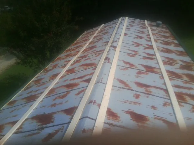 Rusted metal roof panels with new wood purlins before replacement — Storm Damage Roof Repair in Center Point by Roofing Brothers