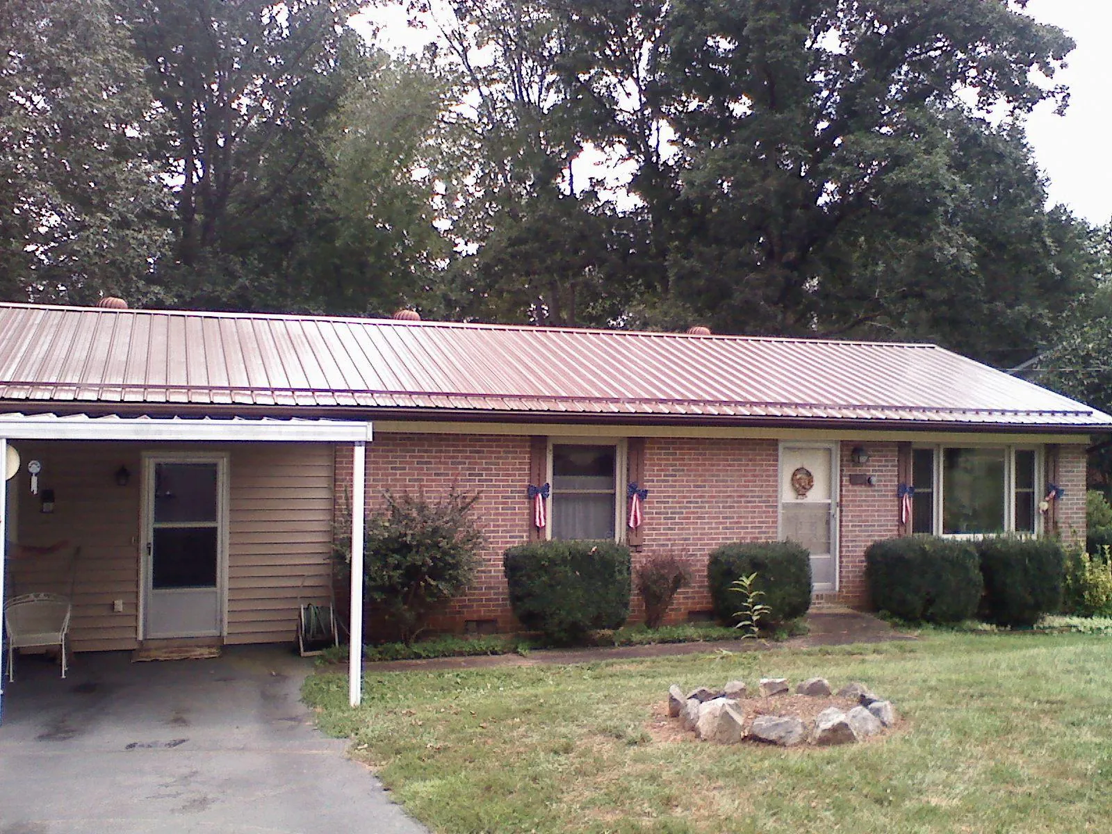 Bronze metal roof and carport on a brick ranch home — Roof Repair work by our crew in Center Point