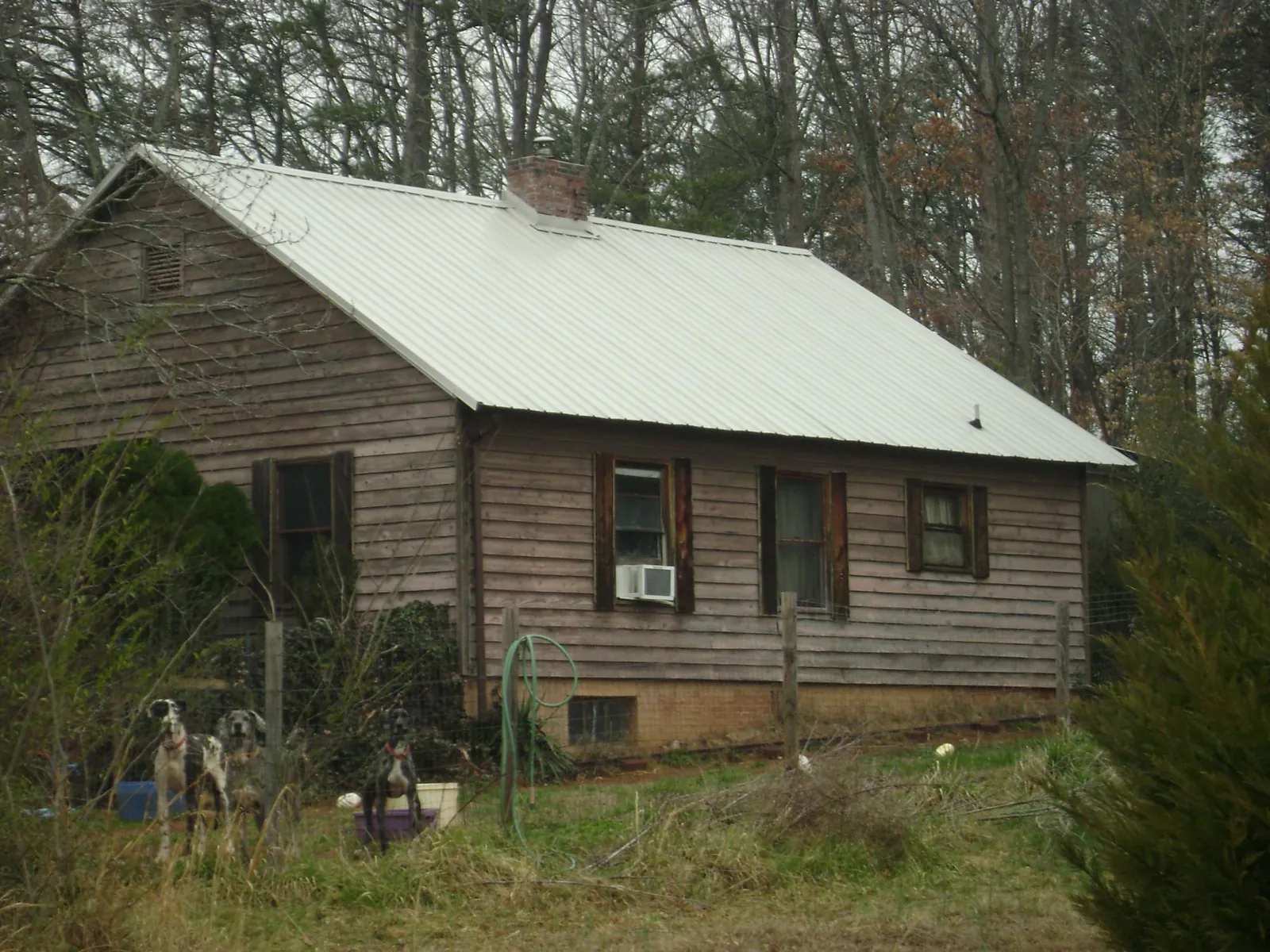 White metal roof on an old wood sided farmhouse, from a Asphalt Shingle Roof Repair job in Center Point